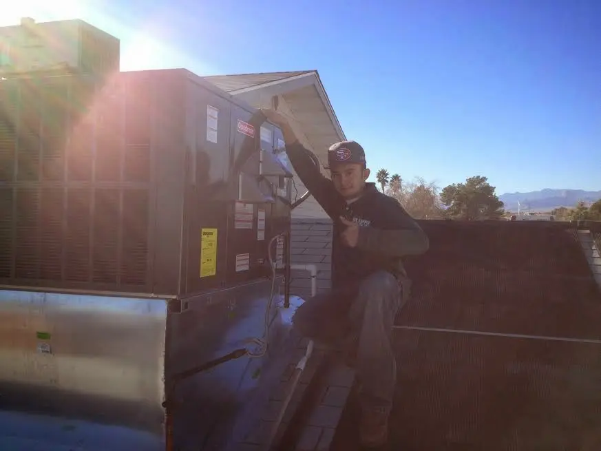 HVAC technician performing Heat Pump Repair on a rooftop unit in Oakland